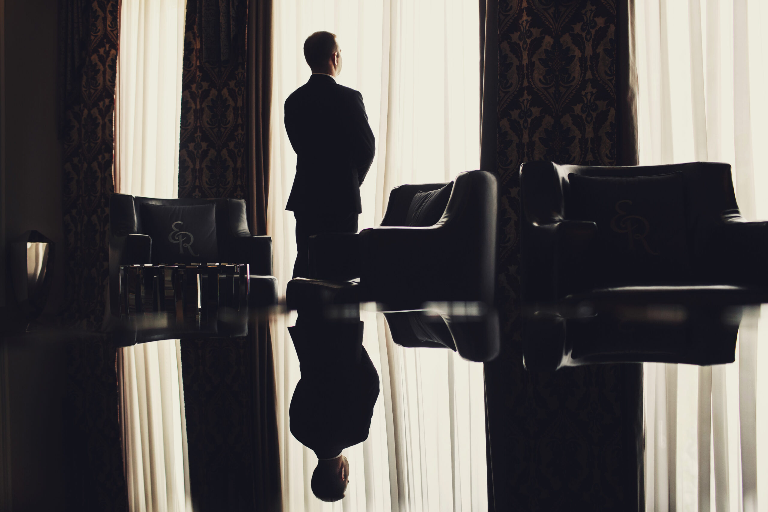 lonely man stands before the window in a room